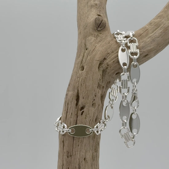 Zware, brede 925 zilveren schakelketting voor heren van 12 mm breed en 60 cm lang. Met gladde ovale platen en langwerpige schakels met reliëf.
